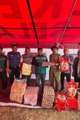 Dokumentasi penyerahan bantuan logistik kemanusiaan di posko Dinas Sosial Bone. Terlihat tim LAZ WIZ dan petugas Dinas Sosial sedang memilah dan menumpuk barang bantuan. Aset logistik yang terlihat jelas di antaranya tumpukan rak telur ayam di dalam wadah plastik, beberapa karung beras premium (merek 788 terlihat pada karung), dan kotak-kotak karton berisi mi instan. Di latar belakang terdapat aktivitas posko dan spanduk informasi yang agak buram. Pencahayaan alami siang hari.