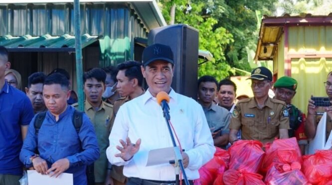 Menteri Pertanian Republik Indonesia Andi Amran Sulaiman bersama Gubernur Sulsel dan Bupati Bone menyerahkan plakat bantuan dana secara simbolis di Posko Bencana Kelurahan Panyula. Suasana penyerahan dihadiri oleh jajaran aparat TNI, Polri, dan warga yang memadati tenda pengungsian darurat.