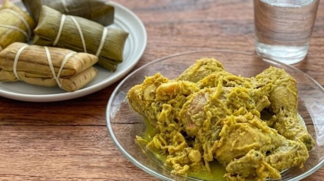 Hidangan tradisional Bugis berupa potongan ayam berbalut bumbu lengkuas kuning (Nasu Likku) di atas piring kaca bening