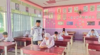 Suasana pelaksanaan Asesmen Madrasah perdana yang menggunakan perangkat smartphone di ruang kelas MIN 5 Bone. Turut terlihat guru pengawas memantau kelancaran ujian.