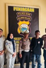 Sejumlah personel Satlantas Polres Bone berseragam lengkap dan petugas Jasa Raharja mengapit seorang pria berkaus hitam yang menjadi tersangka pencurian motor di depan ruang penjagaan Polsek Dua Boccoe.