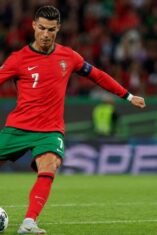 Cristiano Ronaldo bersiap menendang bola di tengah lapangan saat mengenakan seragam Timnas Portugal.