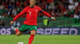Cristiano Ronaldo bersiap menendang bola di tengah lapangan saat mengenakan seragam Timnas Portugal.