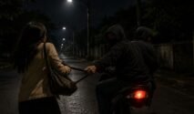 Ilustrasi penjambretan malam hari di jalan gelap dan sepi, memperlihatkan pelaku bermotor menarik tas korban saat melintas.