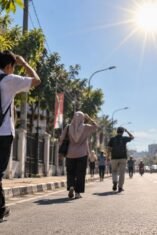 Ilustrasi warga berjalan kaki di jalan beraspal saat cuaca terik, menggambarkan kondisi potensi udara panas di Bone.
