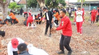 Bupati Bone dan warga menyapu serta mengumpulkan daun kering dalam kegiatan kerja bakti menuju Adipura 2026.